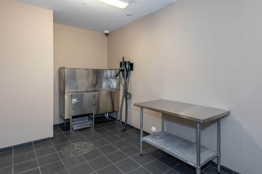 Attain at Quarterpath  apartment homes with A stainless steel washing station and metal table in a clean, tiled room with beige walls.
