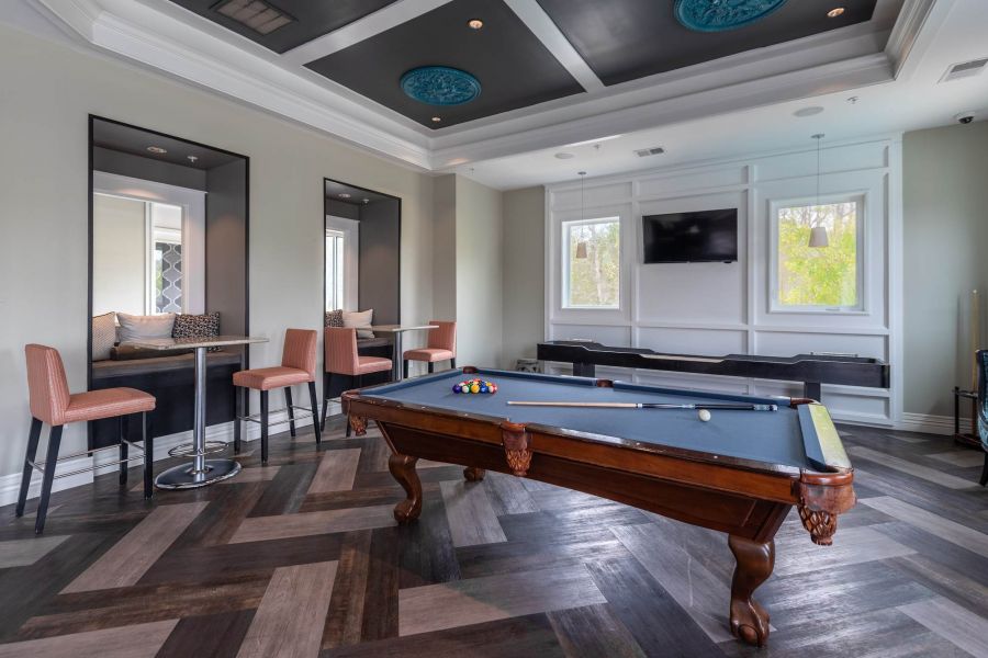 Attain at Quarterpath apartment homes with Modern lounge with a pool table, TV, bar-style tables, and large windows letting in natural light.